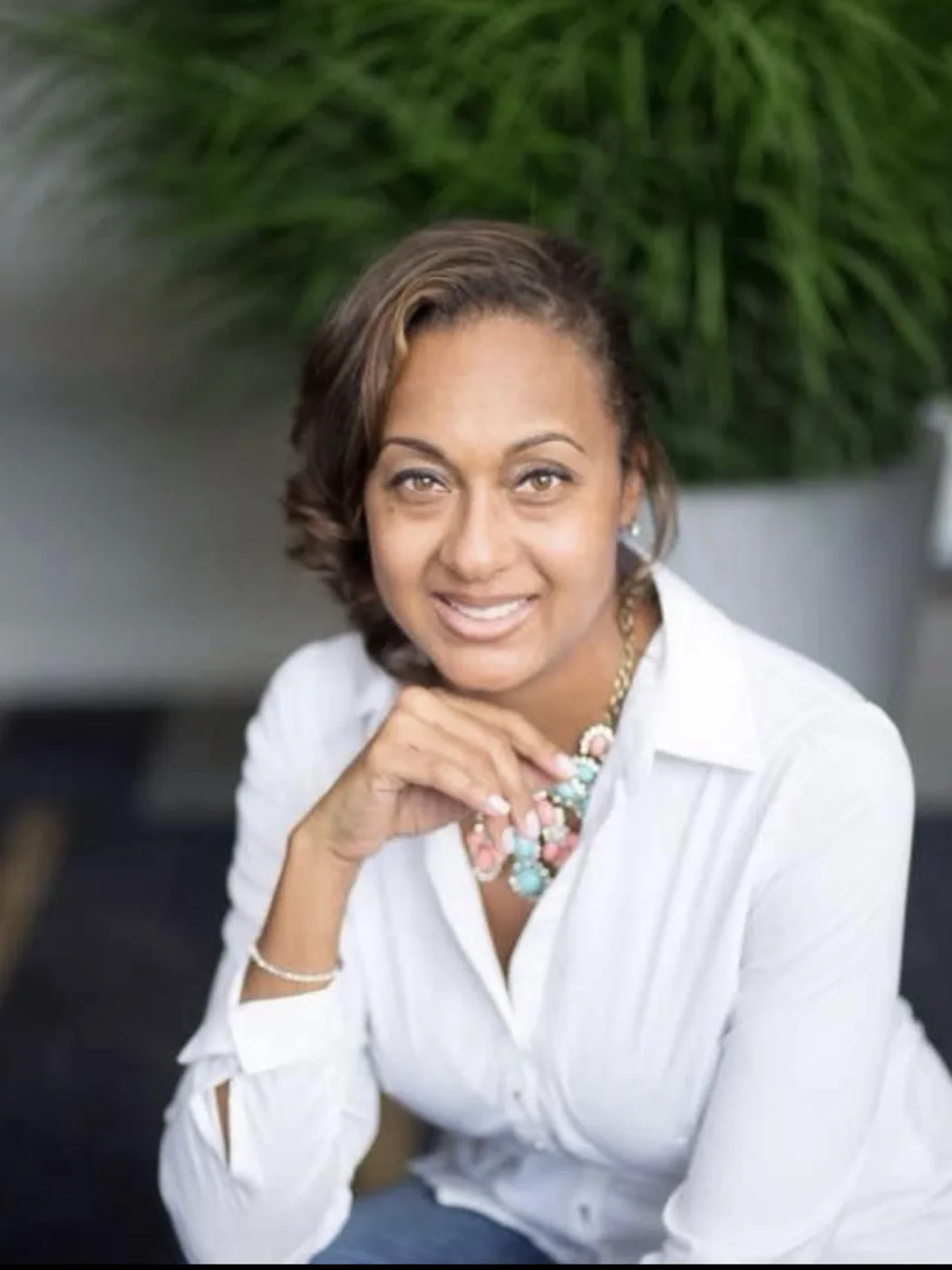 An earlier professional headshot of Nalani York with shorter hair, wearing a white button-down shirt.